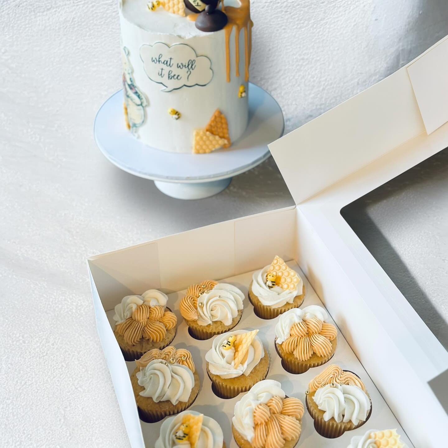 Honey-bee themed gender reveal cake with matching cupcakes in a gift box